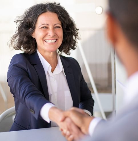 Happy successful business colleagues meeting outside Happy successful business colleagues meeting outside and closing deal. Joyful business woman and man sitting at table, talking and shaking hands. Closing deal concept